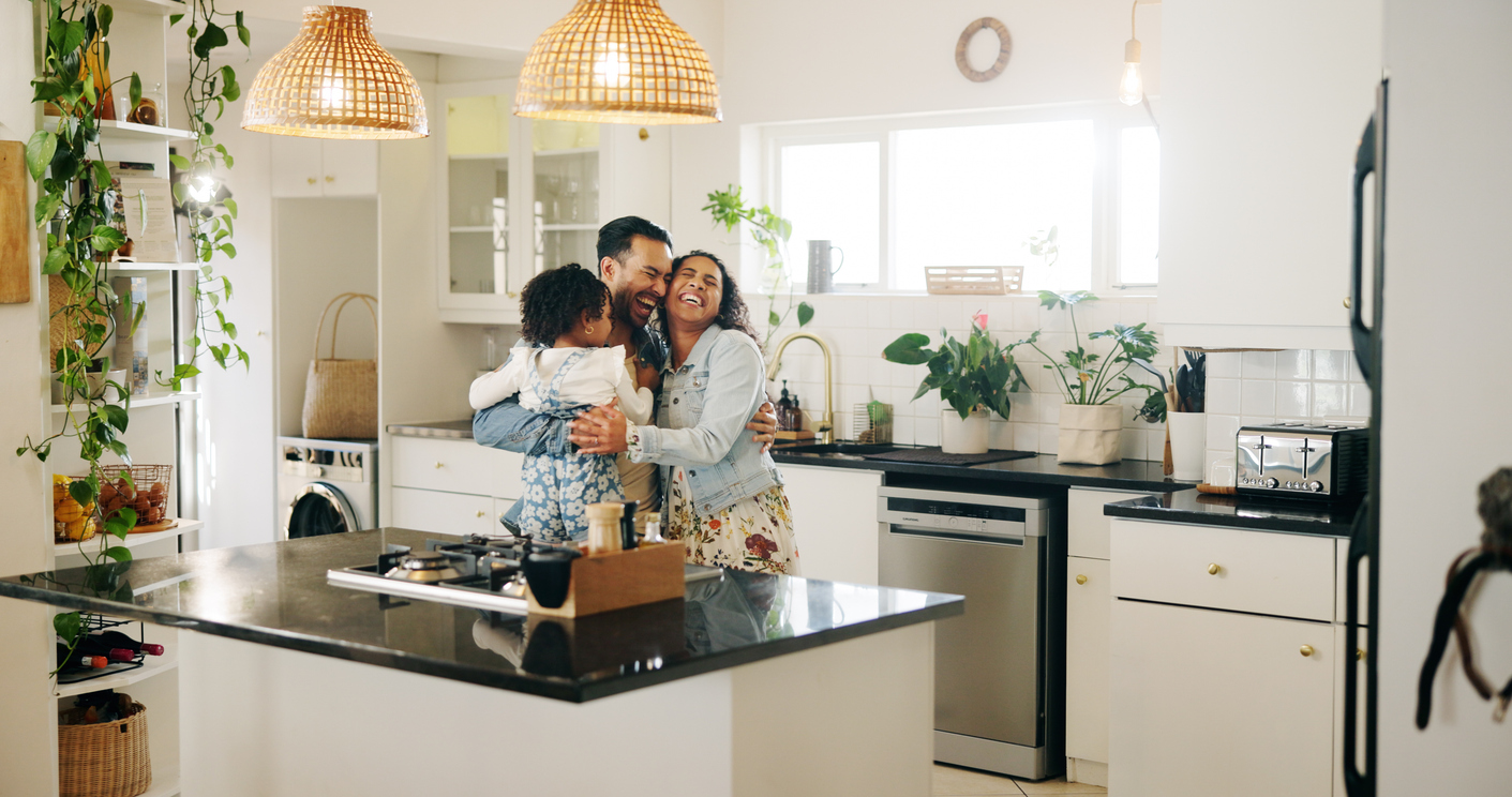 Familia abrazándose en la cocina de su hogar